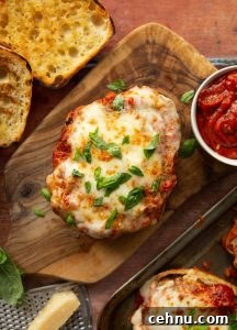 overhead shot of open chicken parmesan sandwich on wooden board