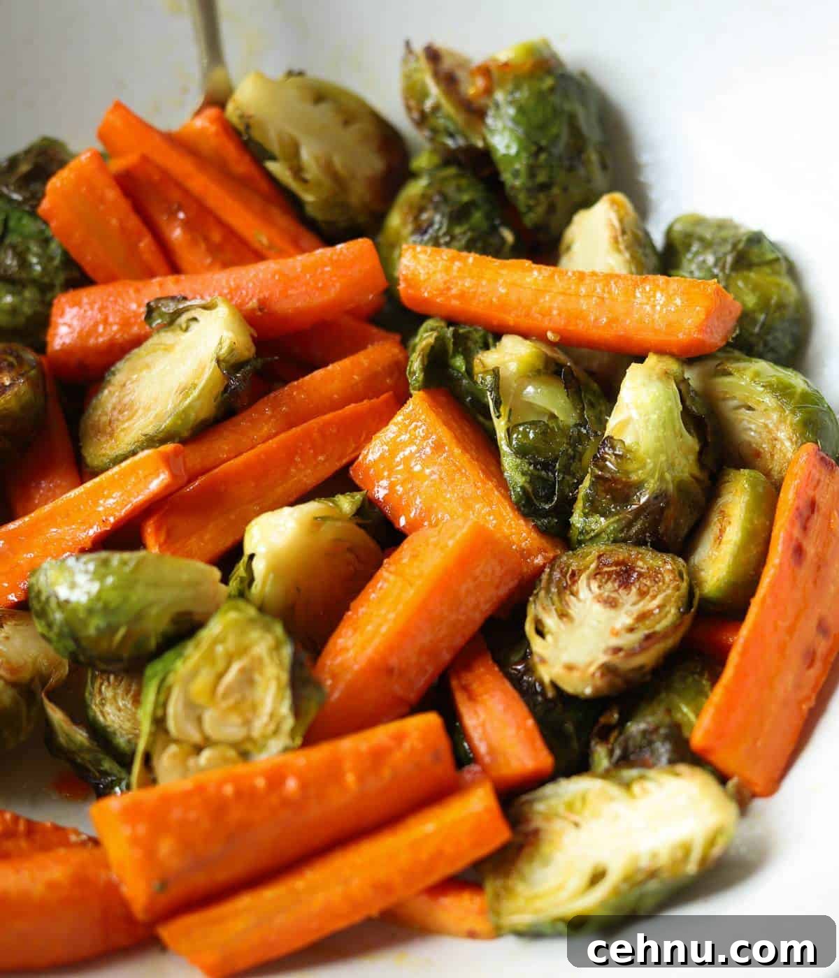 Roasted Brussels Sprouts and carrots with honey butter in serving dish.