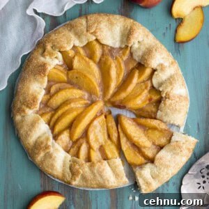 Rustic Peach Crostata or Galette Recipe 10 A peach galette on a green table top, a slice is cut out.