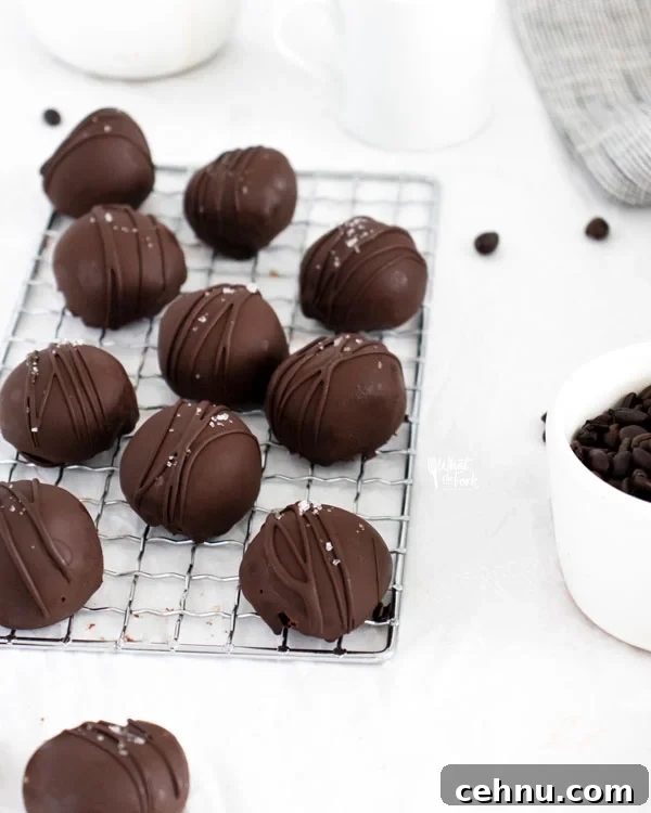 homemade chocolate truffles dipped in chocolate and sprinkled with sea salt on a small wire rack
