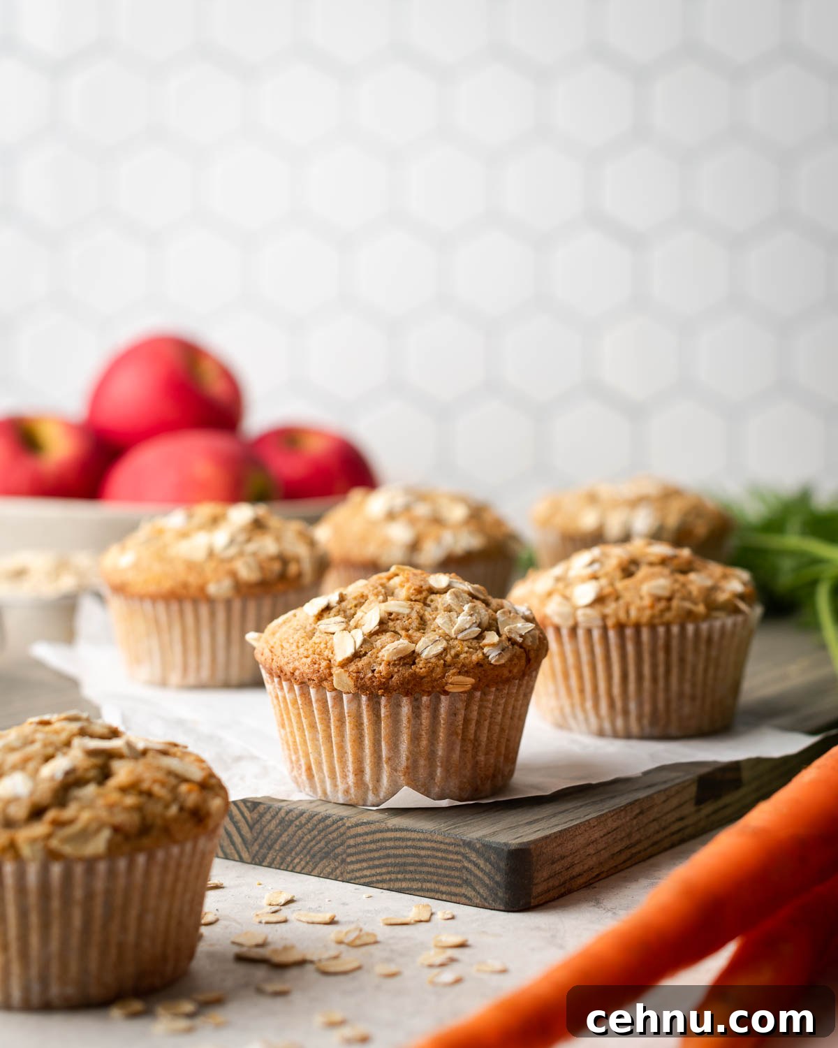 Moist Applesauce Carrot Muffin Recipe with Cinnamon 2 Applesauce carrot muffins sitting on wooden cutting board.