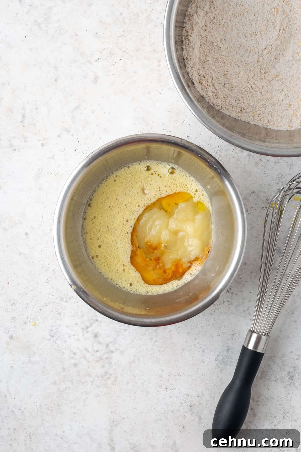 Moist Applesauce Carrot Muffin Recipe with Cinnamon 6 Oil, vanilla, milk, maple syrup and applesauce added to a small mixing bowl containing a beaten egg.