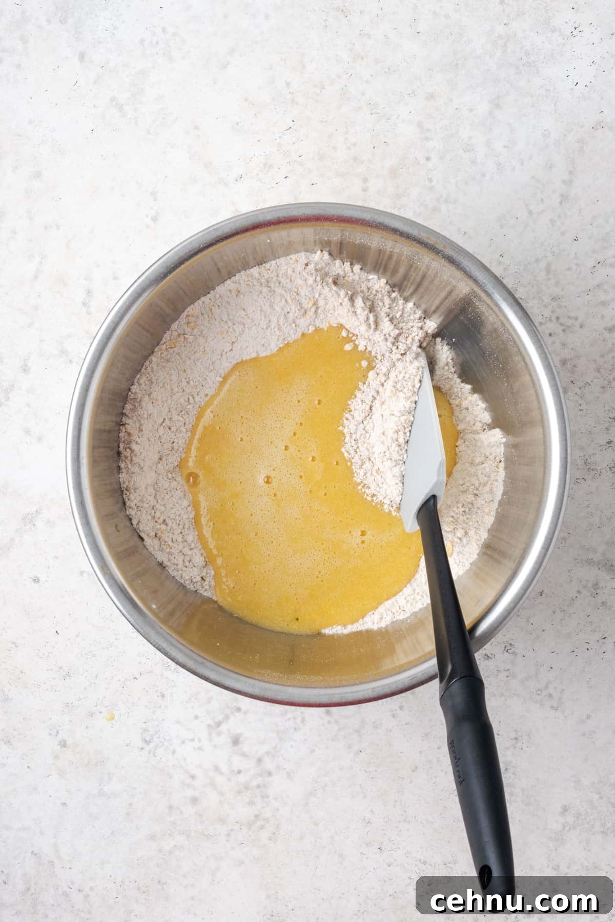 Moist Applesauce Carrot Muffin Recipe with Cinnamon 7 Wet ingredients poured into the dry ingredients into a large metal mixing bowl.
