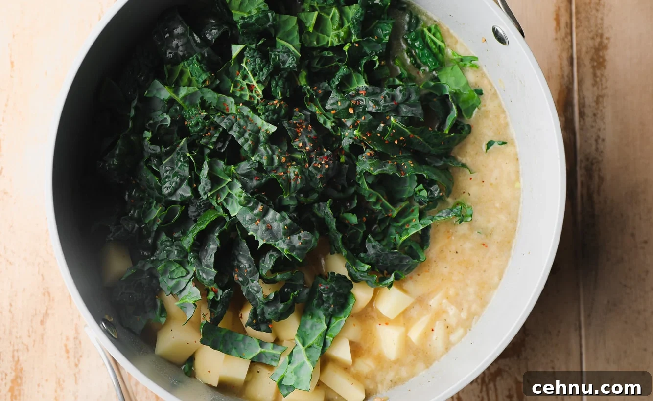 kale, potatoes, and broth in a large grey pot.