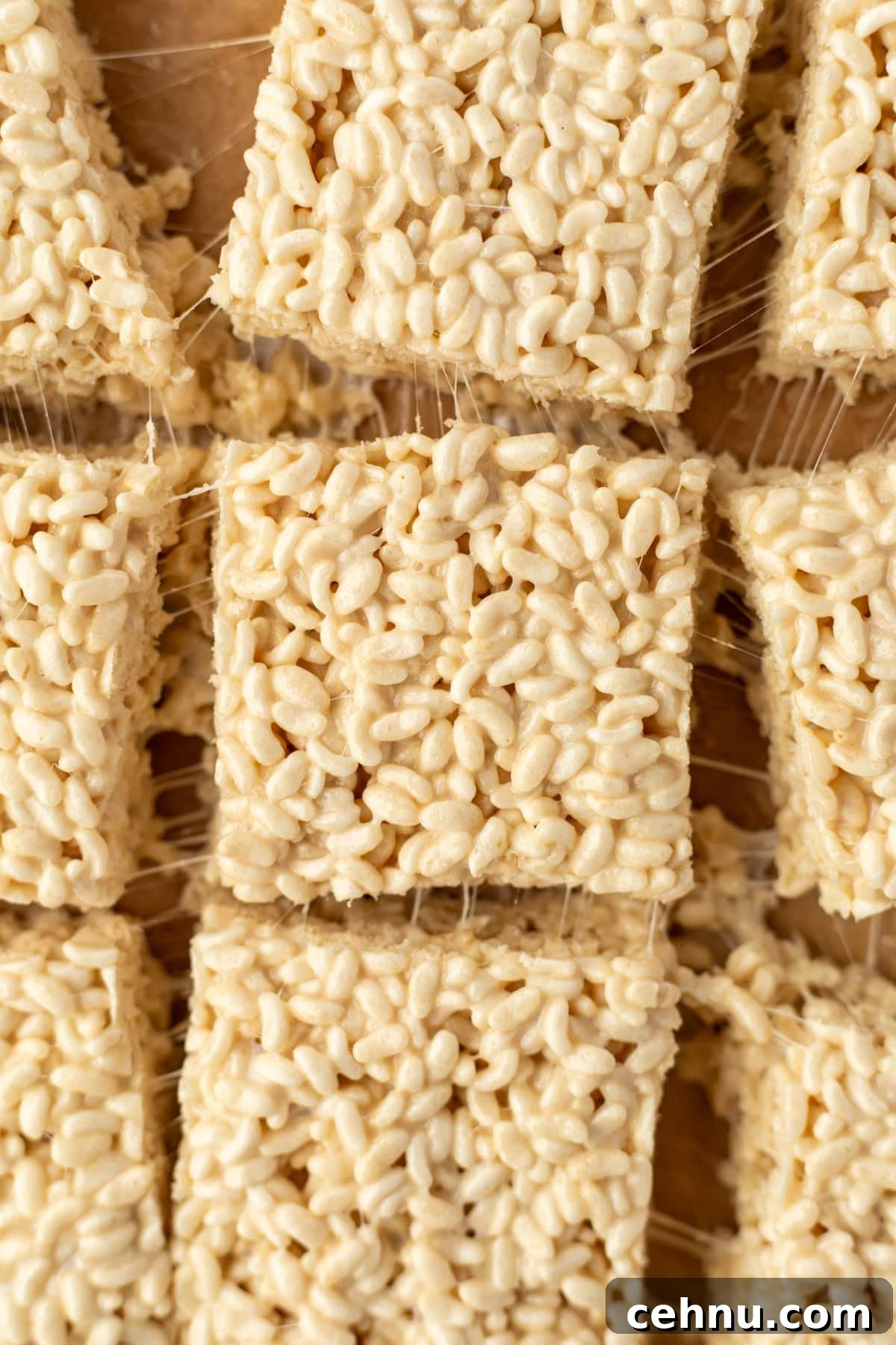 Gluten-Free Rice Krispie Treats Recipe 2 Rice krispie treats with gooey strands holding them close to one another.