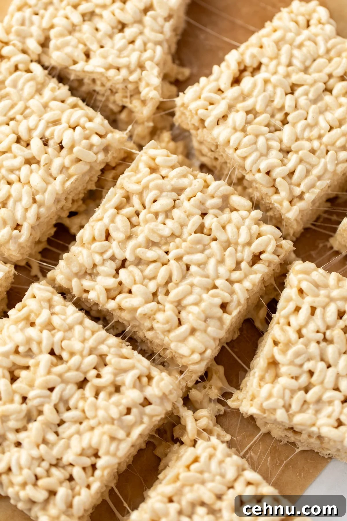 Gluten-Free Rice Krispie Treats Recipe 6 Gooey rice krispie treats on a parchment paper background.