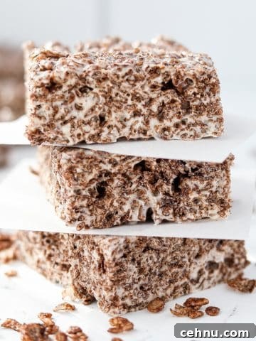 A stack of three cocoa pebbles treats on a marble countertop.