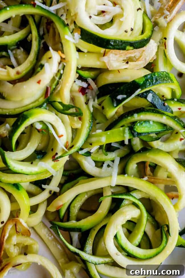 Close-up of curly zoodles with cheese.