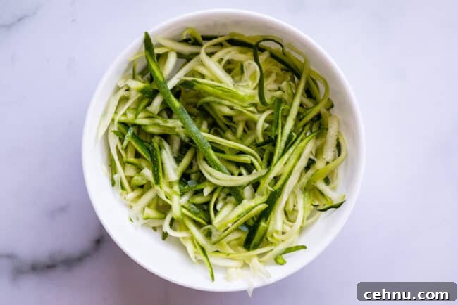 Straight zoodles in a white bowl on a counter.