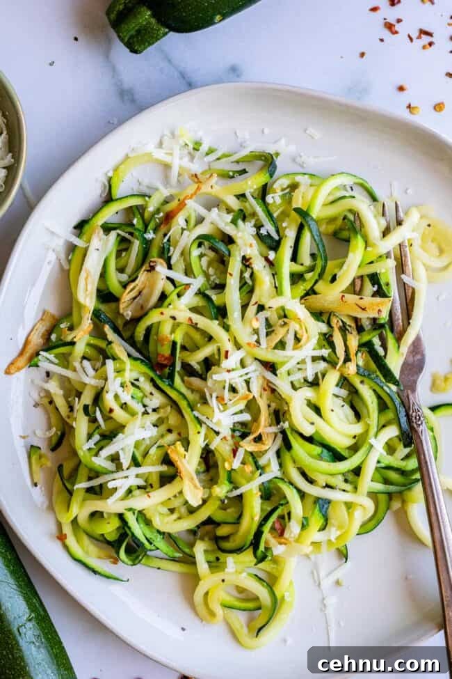 Zucchini noodles on a plate with cheese and spices.