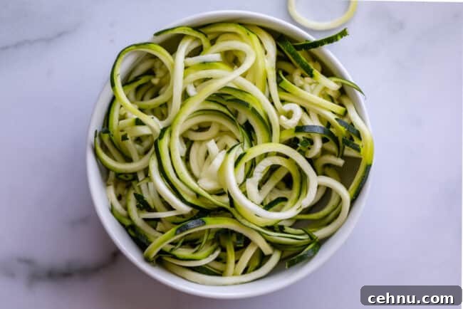 Curly zoodles in a white bowl.