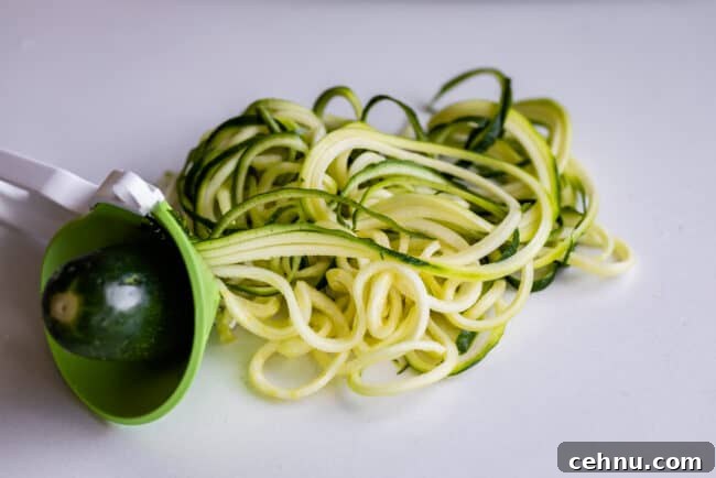 Zucchini turned into zoodles using a handheld device.
