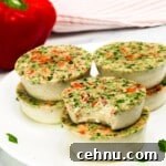 keto egg bites on a white plate with a bell pepper in the background, one bite taken out of one egg bite
