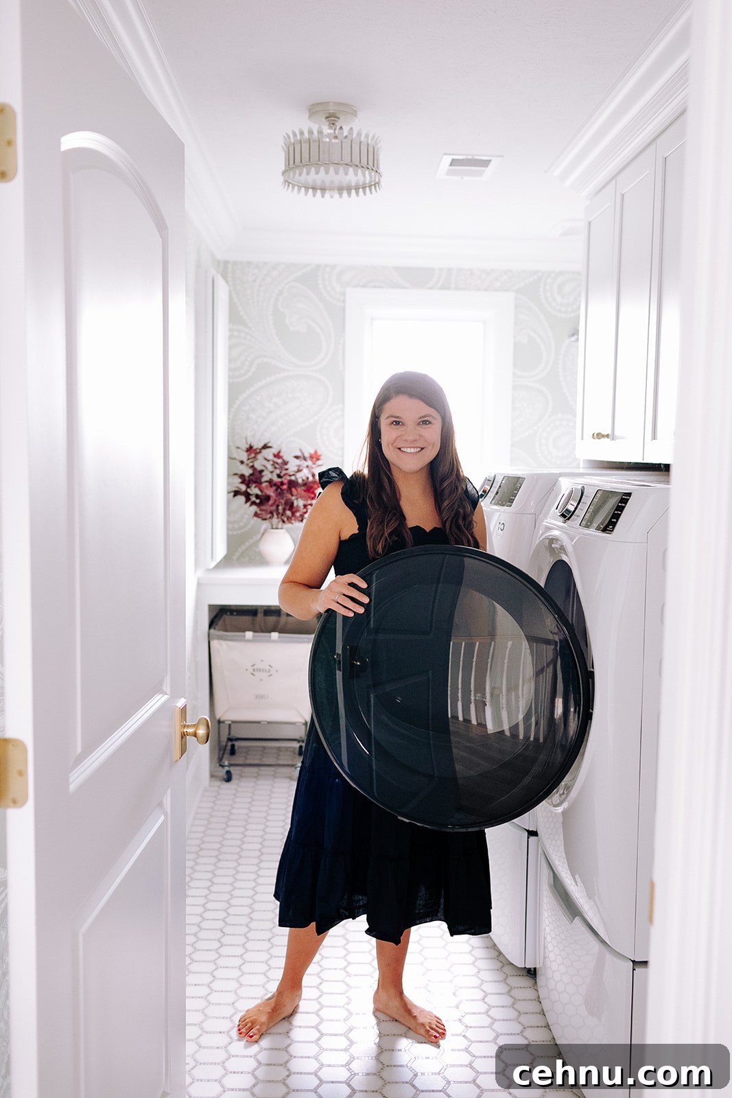 Allianna moximchalk in a black dress standing inside her laundry room.