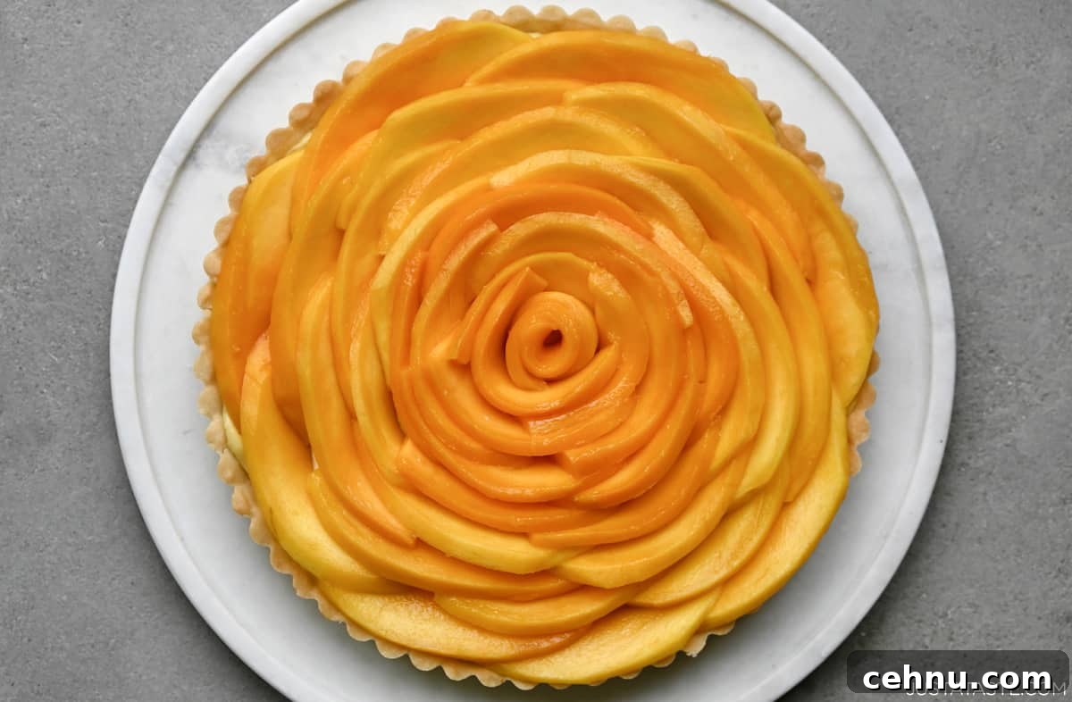 A mango tart that looks like a giant flower on a round serving tray.