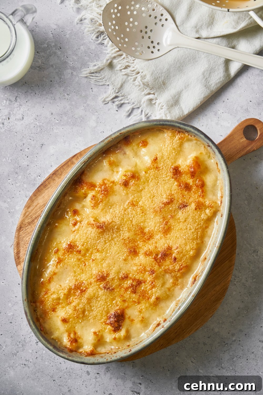 Ham and potato casserole on top of a wooden board.