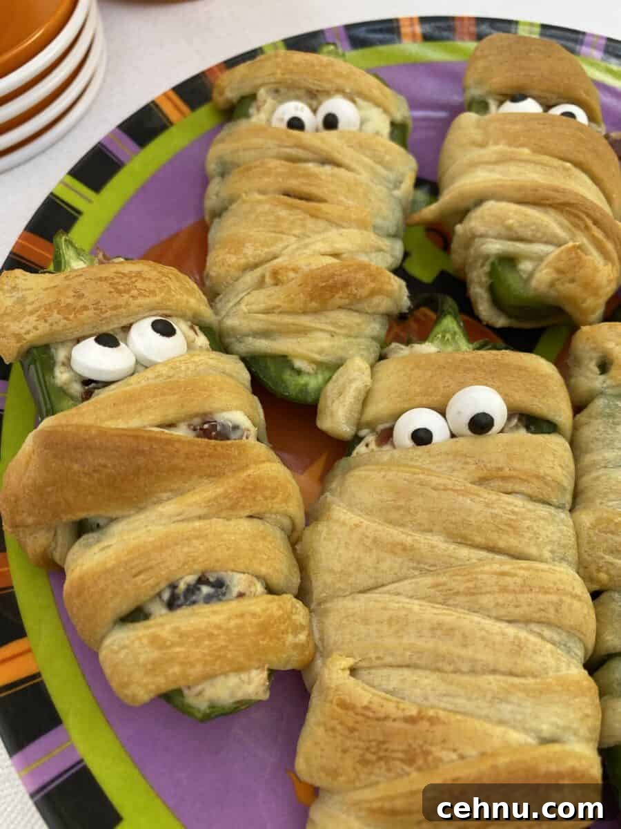 Bacon Wrapped Jalapeno Popper Mummies 6 Jalapeno popper wrapped with dough and displaying candy eyes.