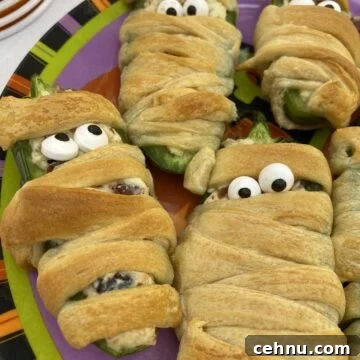 Bacon Wrapped Jalapeno Popper Mummies 7 Jalapeno popper wrapped with dough and displaying candy eyes.