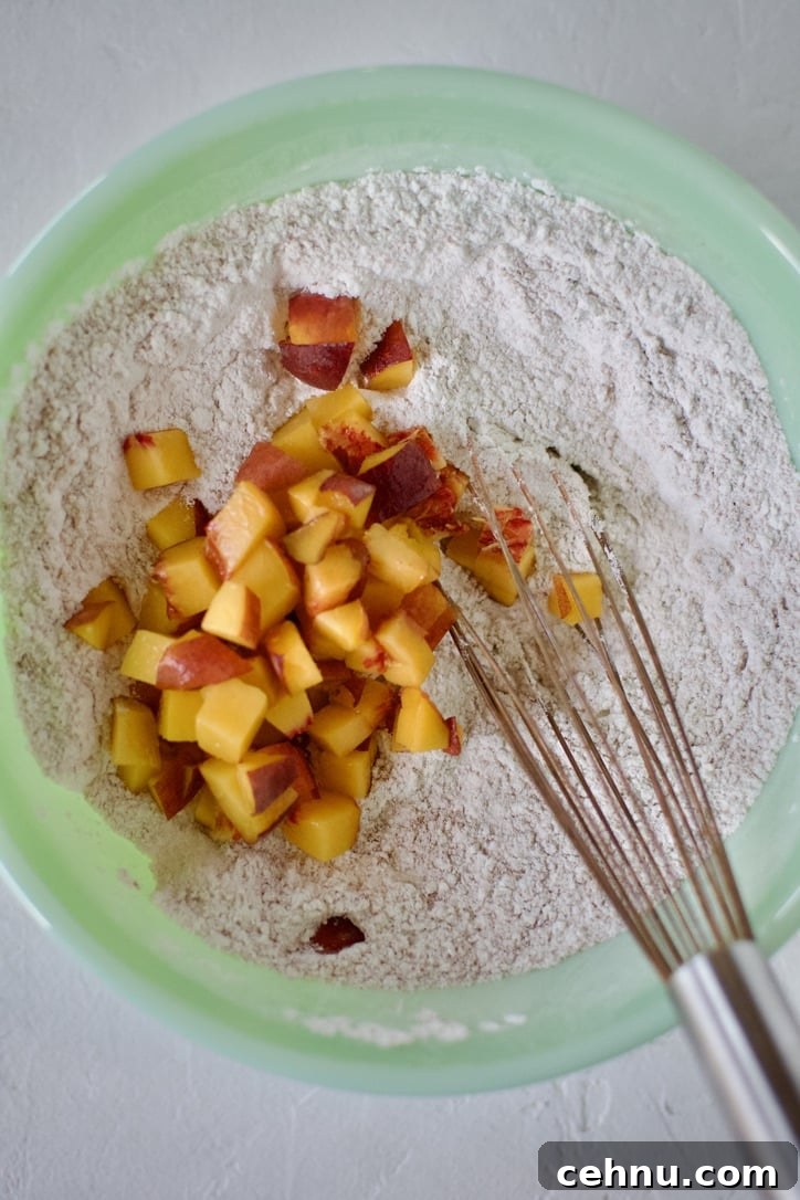 Adding diced peaches to the mixed dry pancake mix.