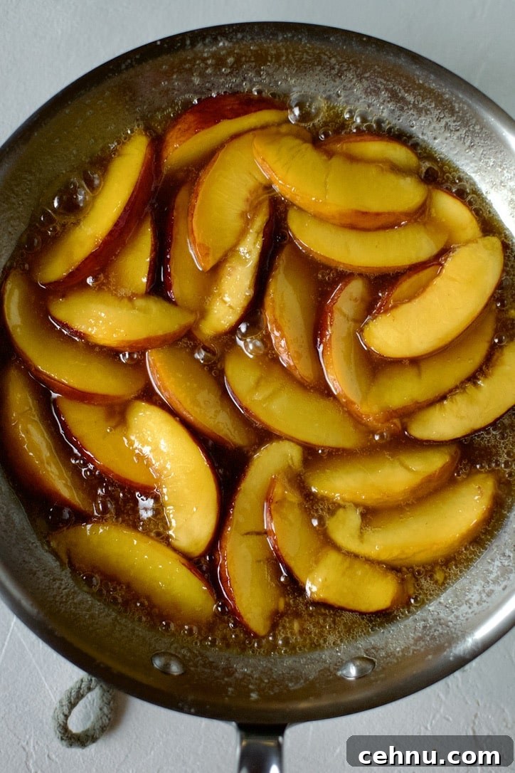 Maple syrup and whiskey added to the sauteed peaches, ready to top cooked pancakes.
