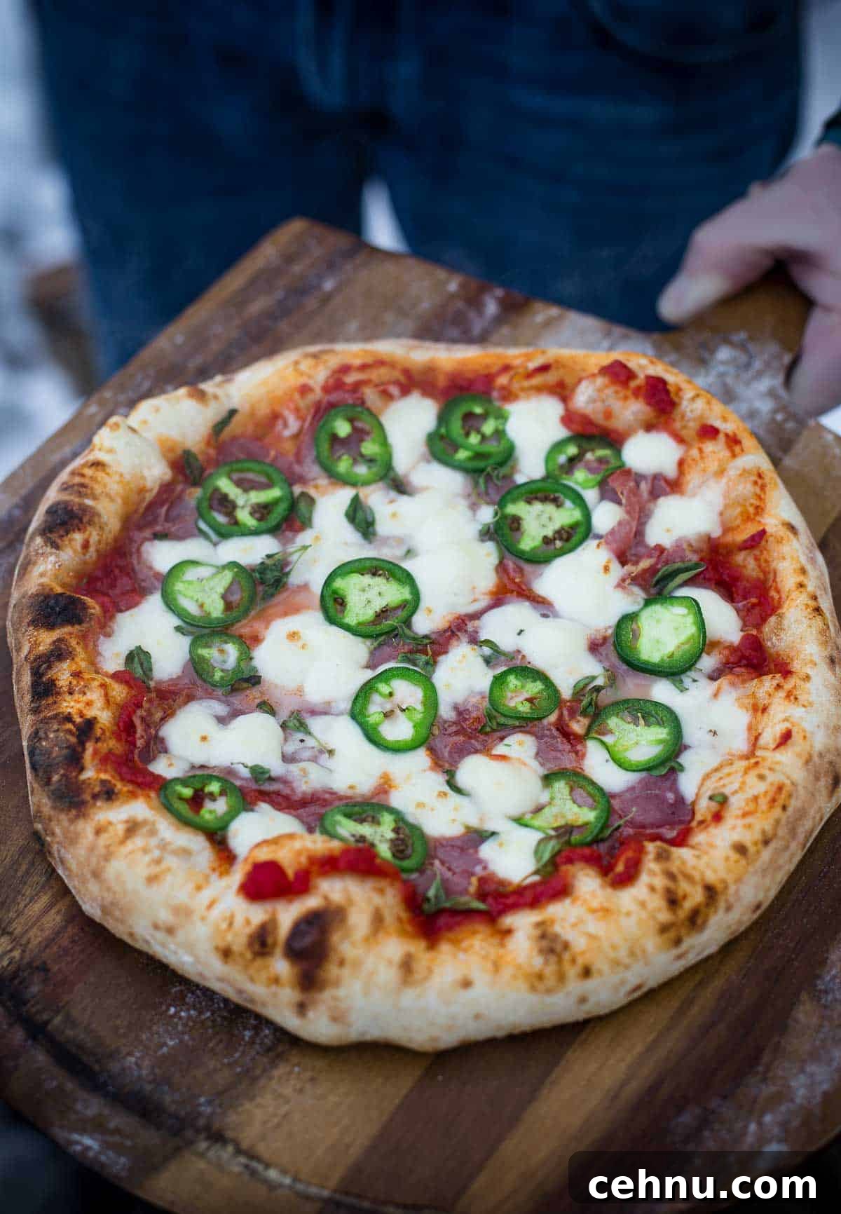 Neapolitan style pizza with jalapeño and coppa on a cutting board