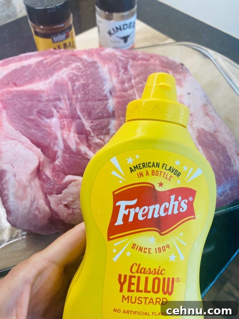 Smoked Pulled Pork with Fireball Cinnamon Whiskey Glaze 3 adding mustard to the pork