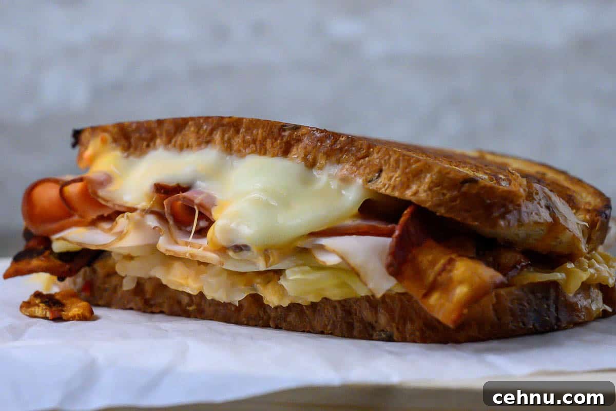 Reuben Club Sandwich with Corned Beef, Swiss and Sauerkraut 8 Bacon Reuben Sandwich on parchment paper.