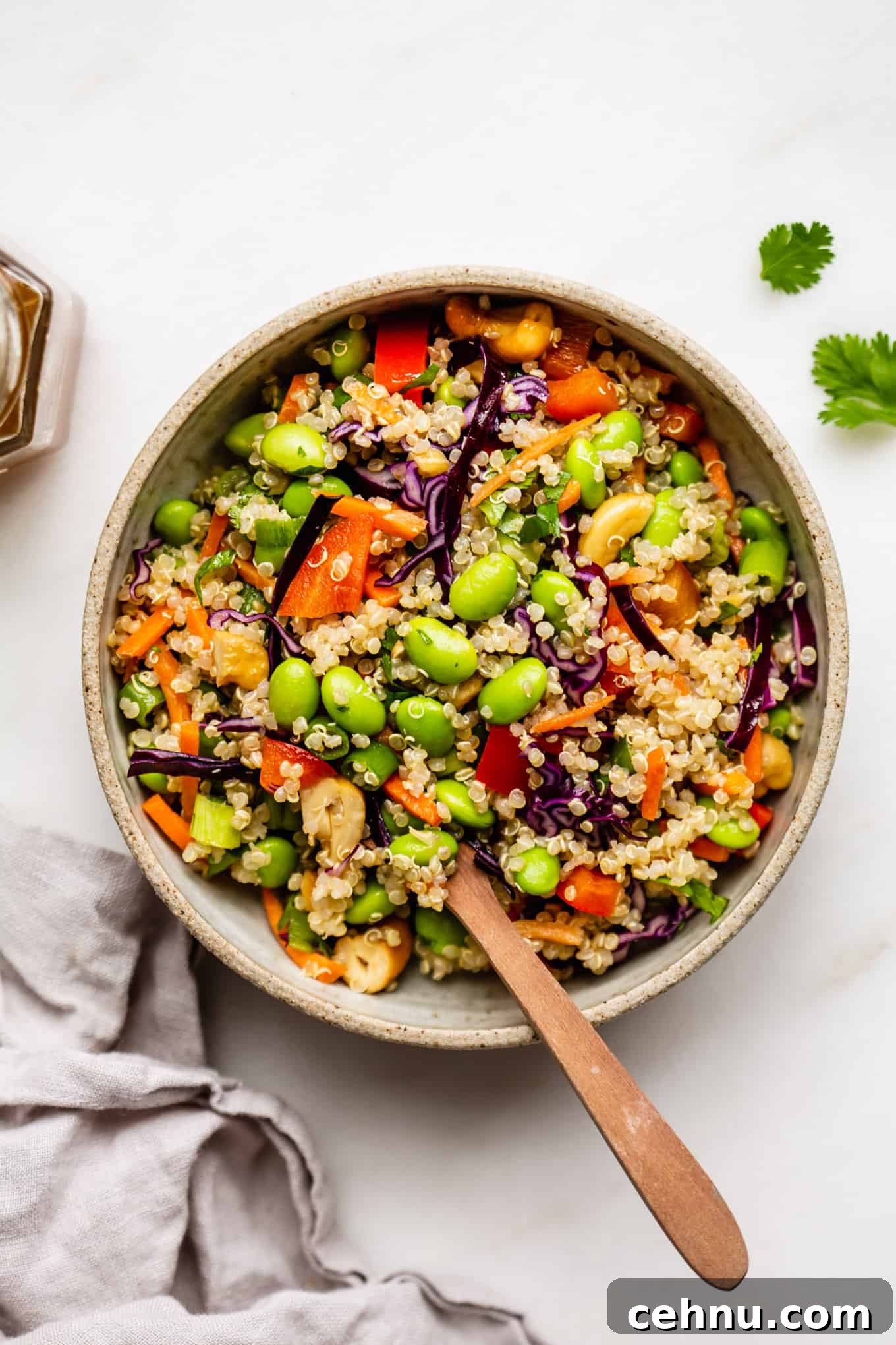 A bowl of edamame salad with a wood spoon in it