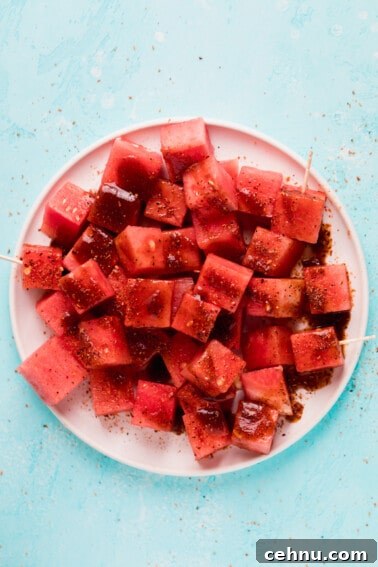 Tajin Seasoning: What It Is and How to Use It 4 Overhead view of white plate with cubed watermelon and tajin with chamoy.
