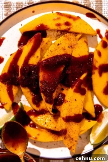 Tajin Seasoning: What It Is and How to Use It 5 Plate with sliced mango, drizzled in chamoy and sprinkled with tajin.