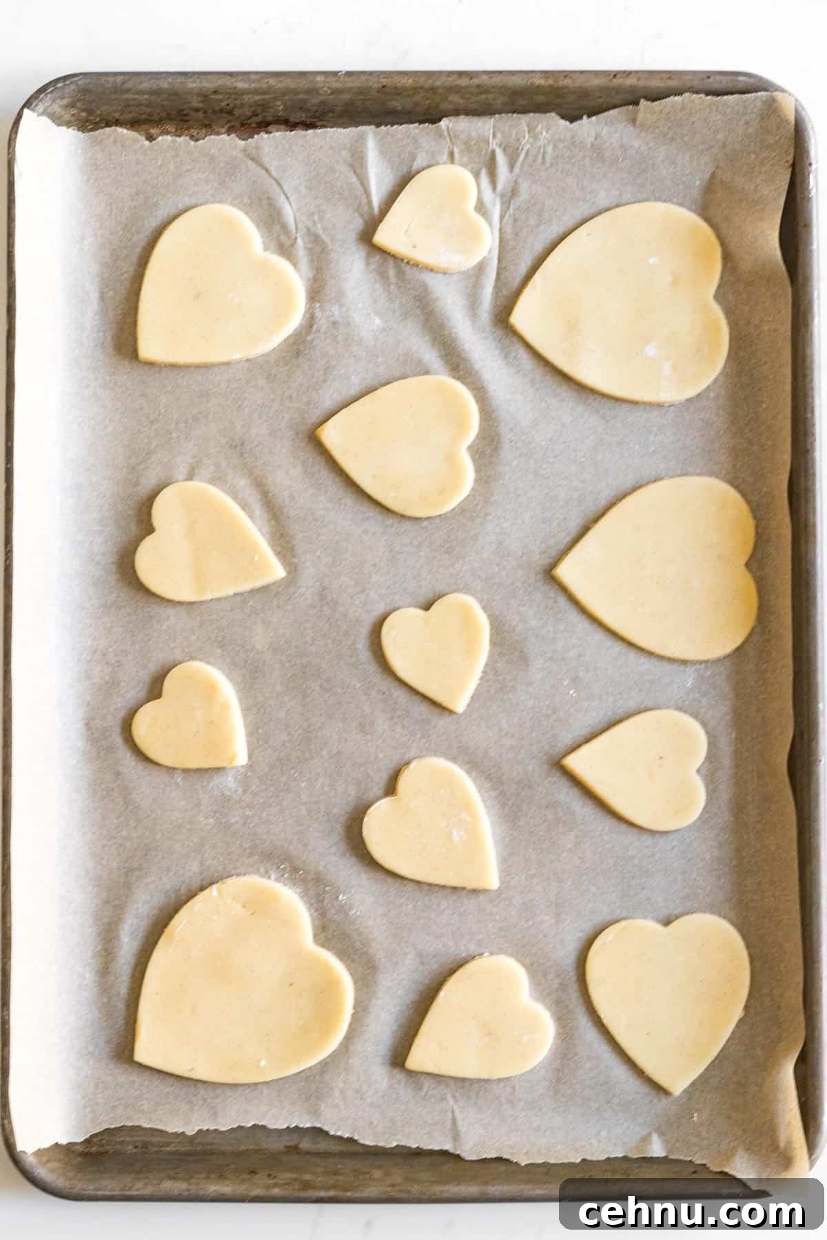 Marbled Sugar Cookie Recipe with Decorating Tips 3 sheet tray line with parchment paper with different sized heart cut out sugar cookies