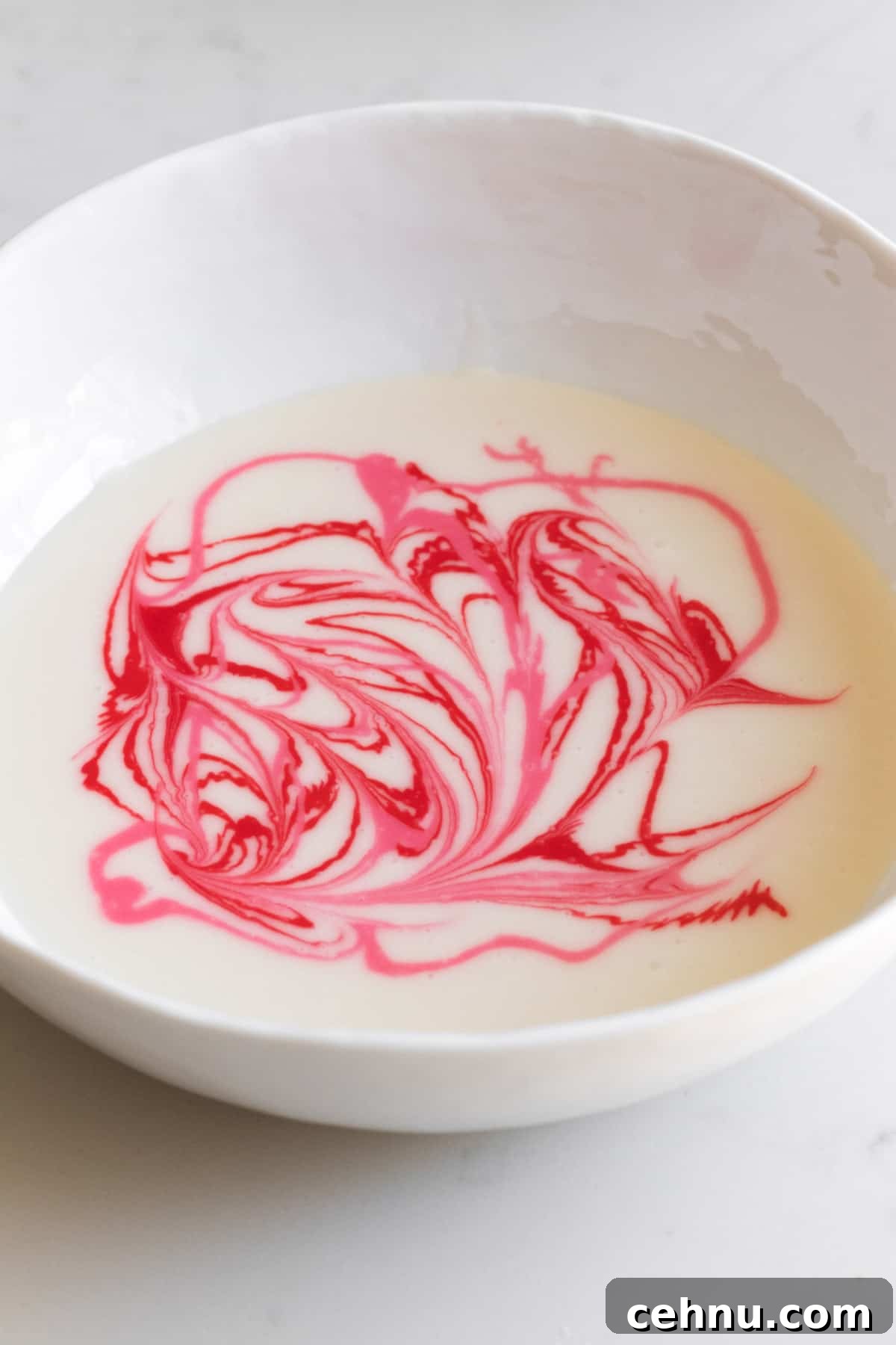 Marbled Sugar Cookie Recipe with Decorating Tips 7 bowl of white icing with pink and red swirls in it