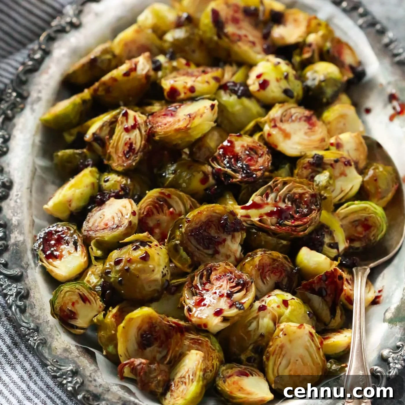 Easter Menu Ideas: Brunch, Dinner and Dessert Recipes 19 Pomegranate glazed brussels sprouts on a silver serving dish.