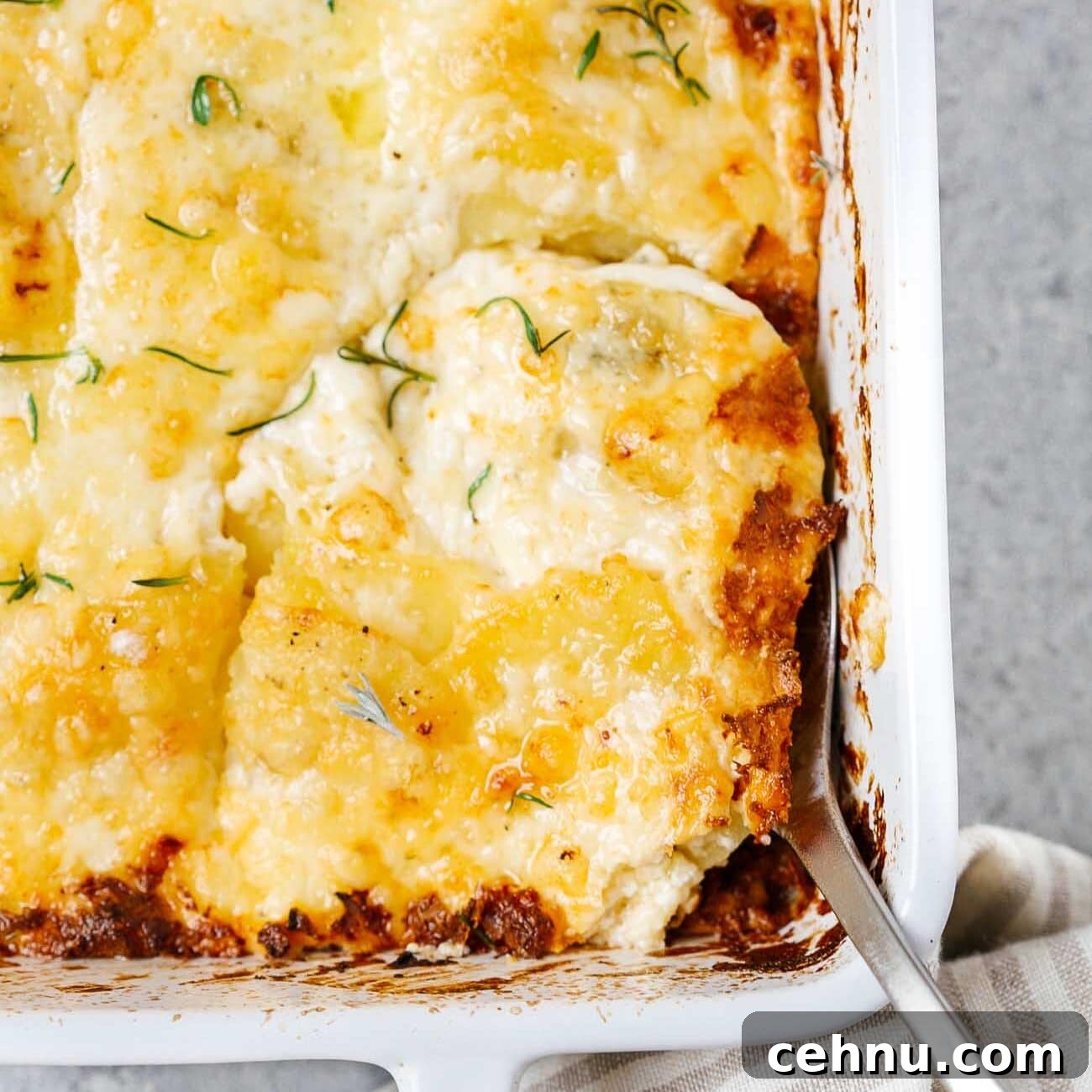 Easter Menu Ideas: Brunch, Dinner and Dessert Recipes 21 Overhead view of potatoes au gratin in a white casserole dish.
