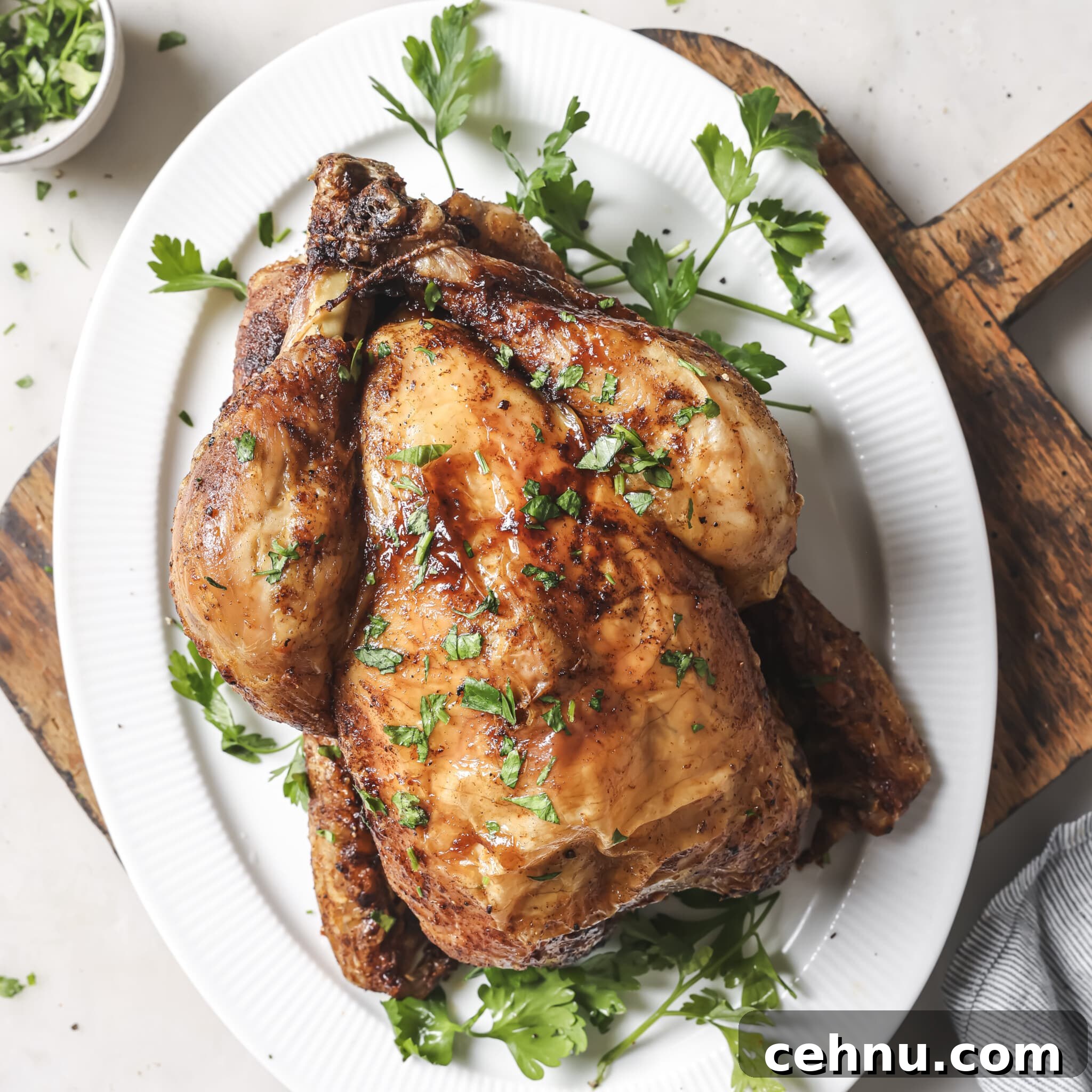 Easter Menu Ideas: Brunch, Dinner and Dessert Recipes 25 Air Fryer Whole Chicken on a white serving platter.