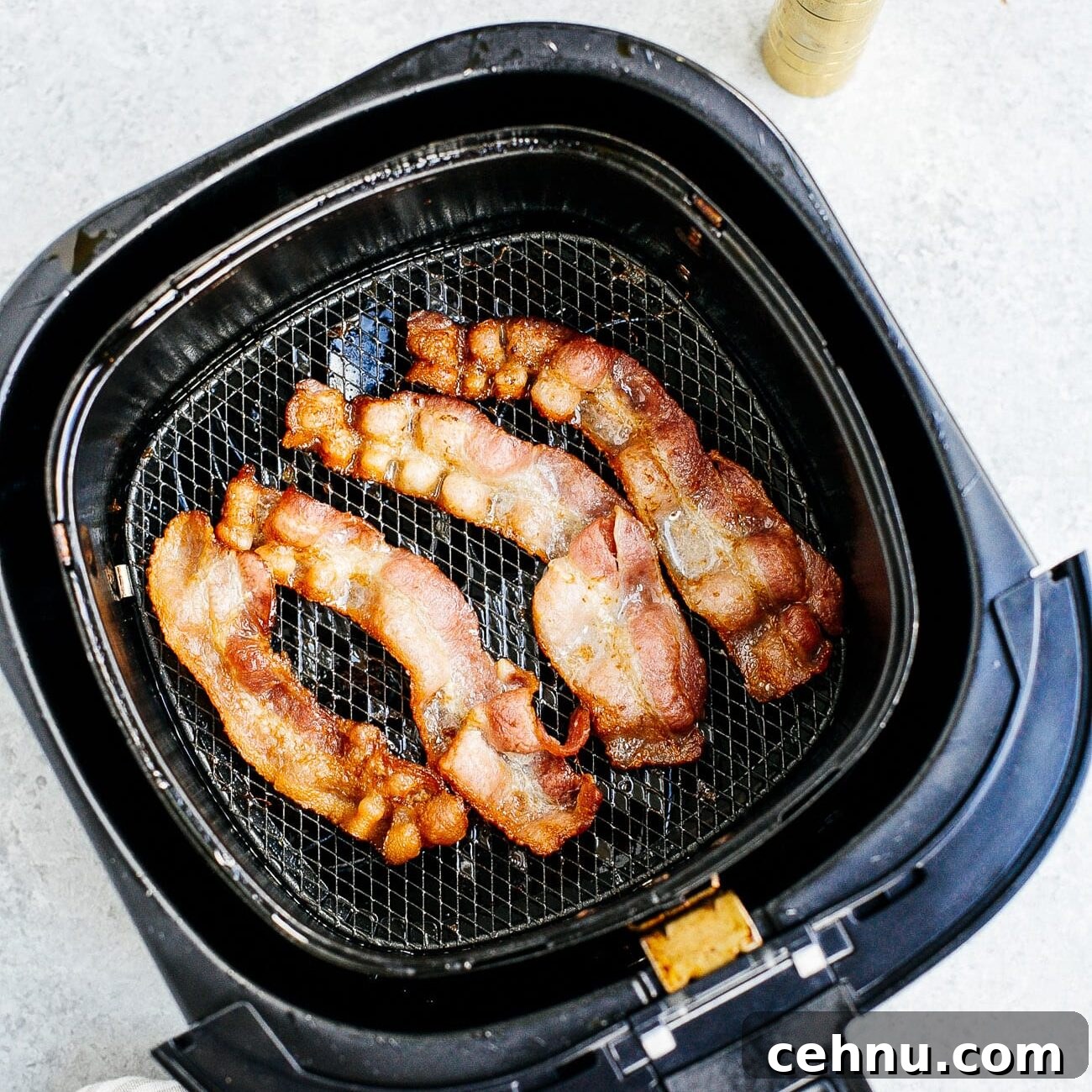 Easter Menu Ideas: Brunch, Dinner and Dessert Recipes 8 Overhead view of cooked bacon inside of a air fryer basket.