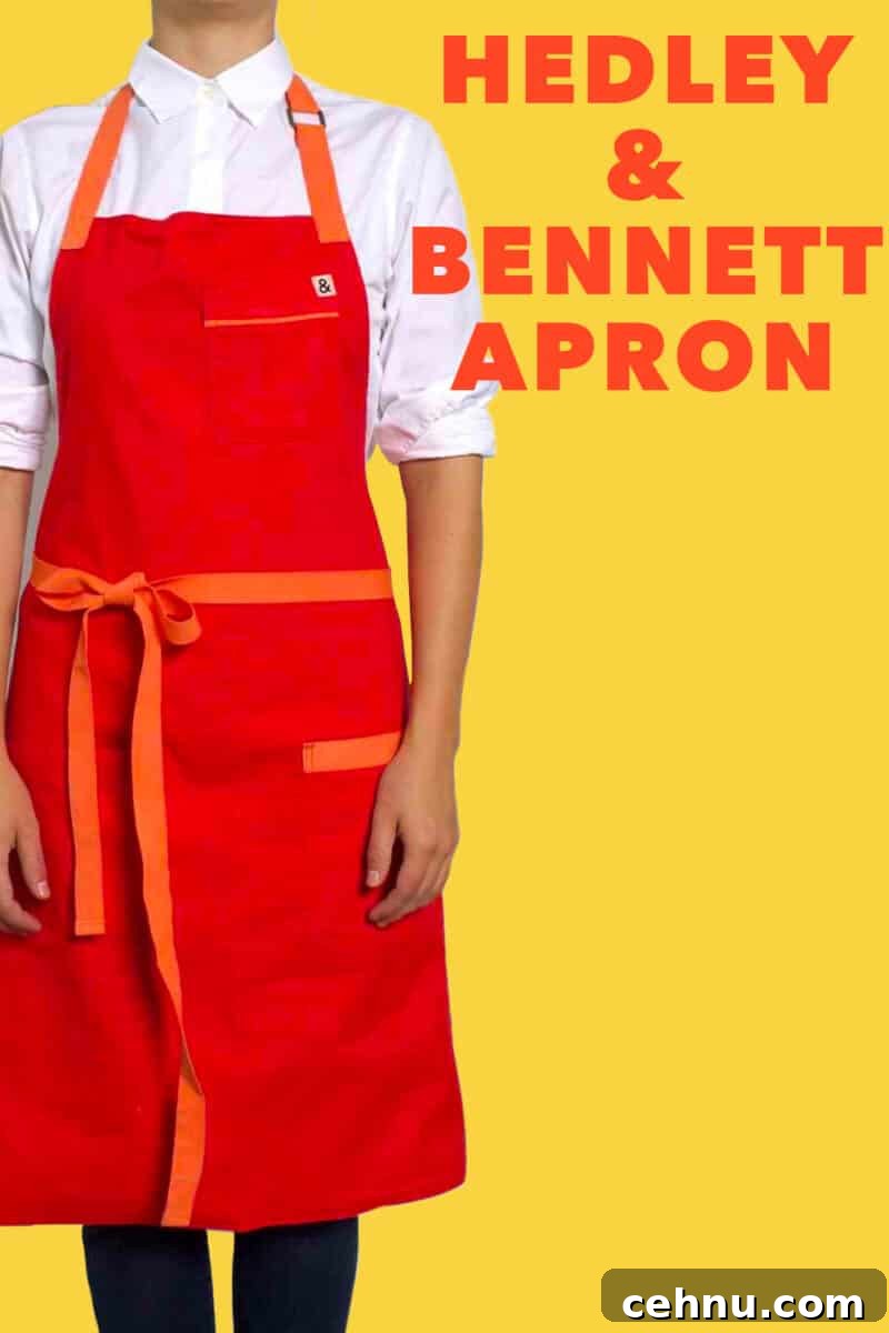 A person in a red Hedley and Bennett apron against a yellow background 