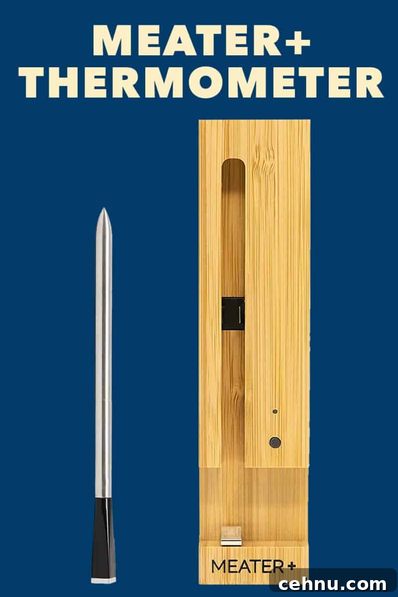 An overhead shot of a Meater Plus thermometer and wooden charging block on a dark blue background.