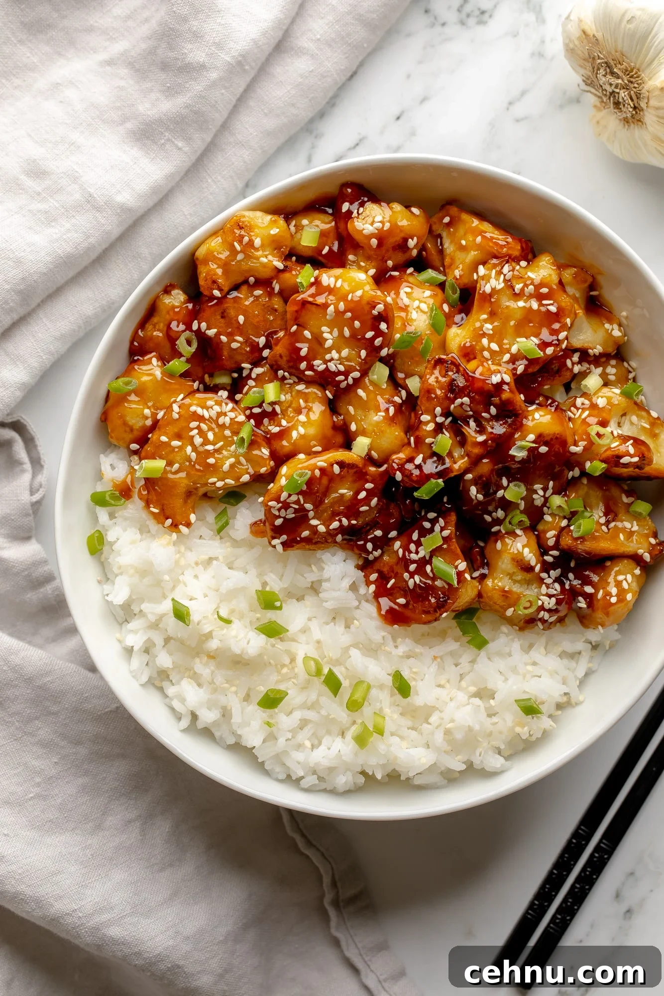 Overhead view of sesame cauliflower in a bowl with rice.