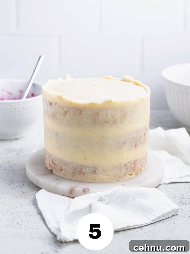 Frosted cake on a round marble slab.