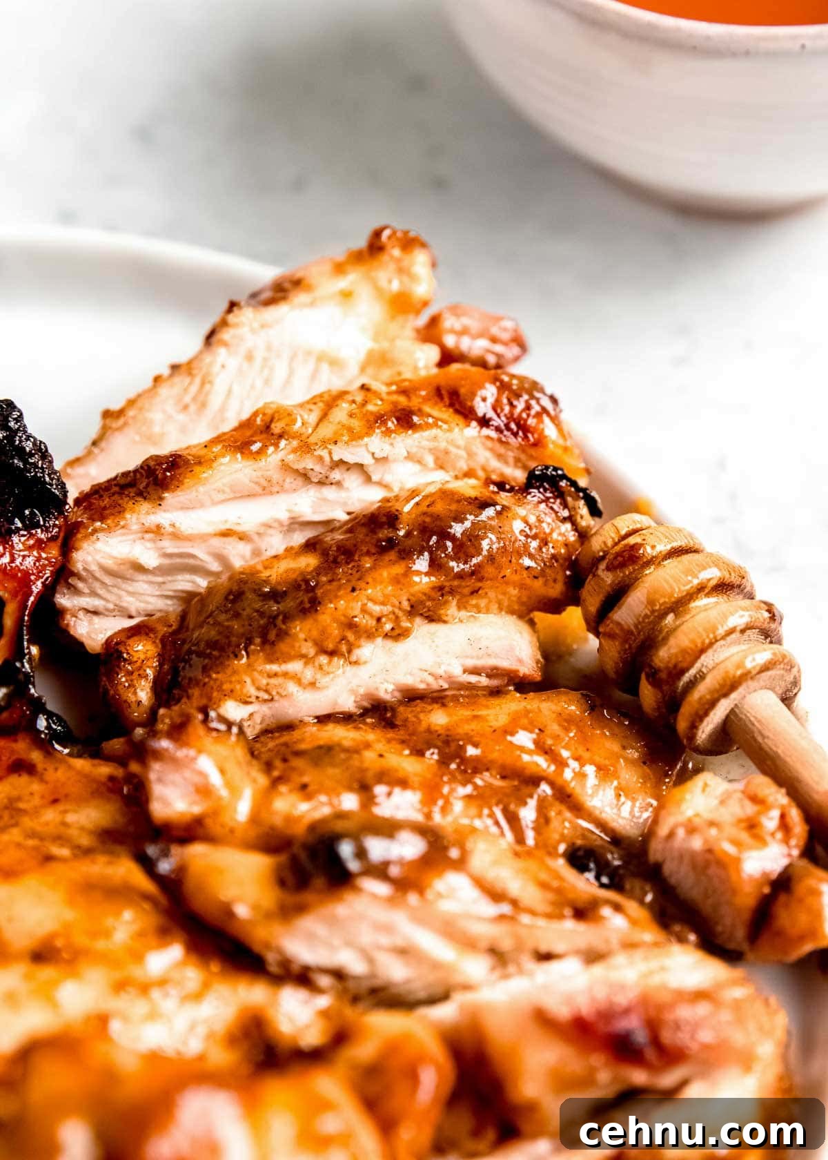 sliced honey mustard chicken on a white plate 