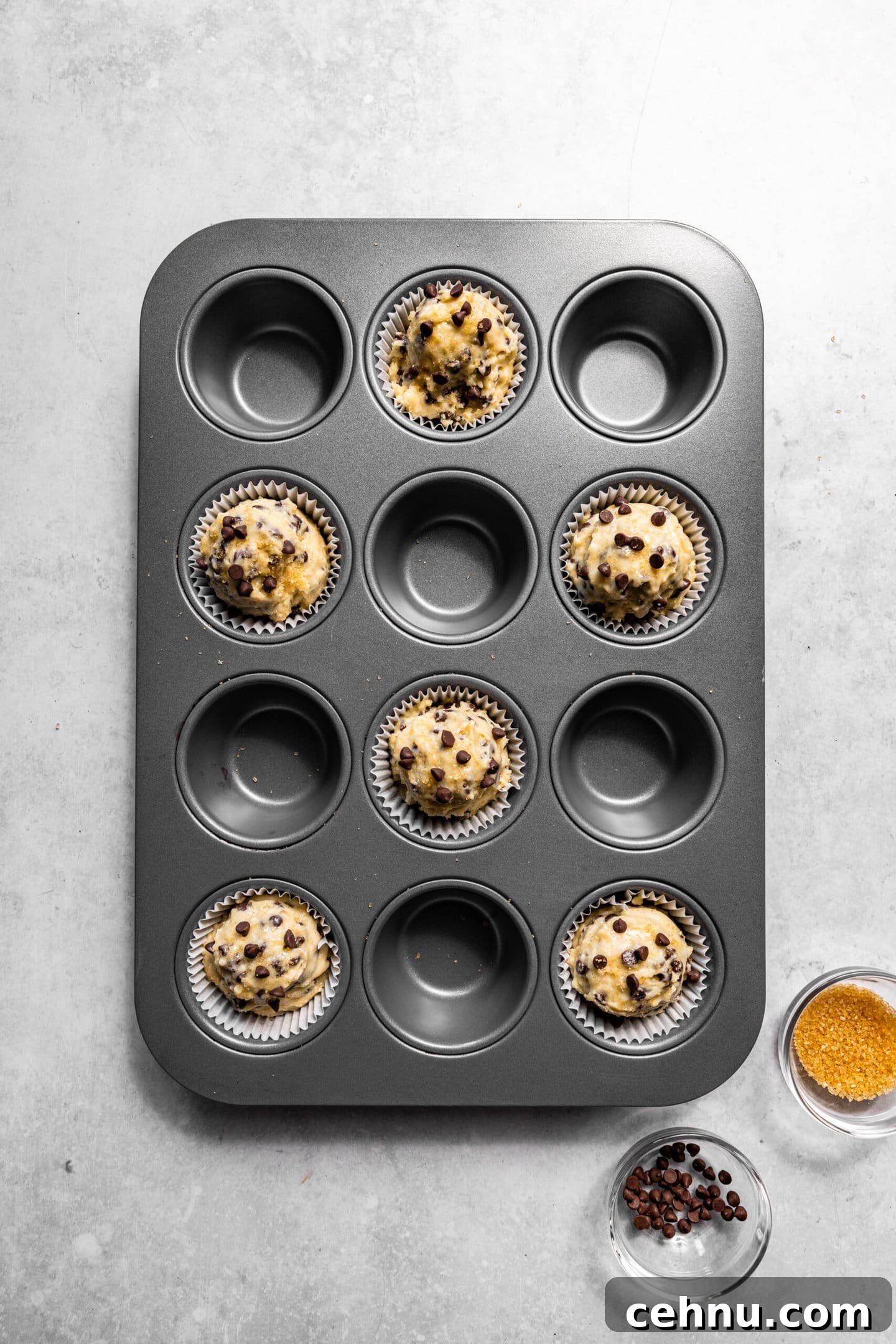 Chocolate Chip Muffins with Sour Cream (Small Batch) 9 Muffin batter scooped into muffin pan with raw sugar sprinkled on top