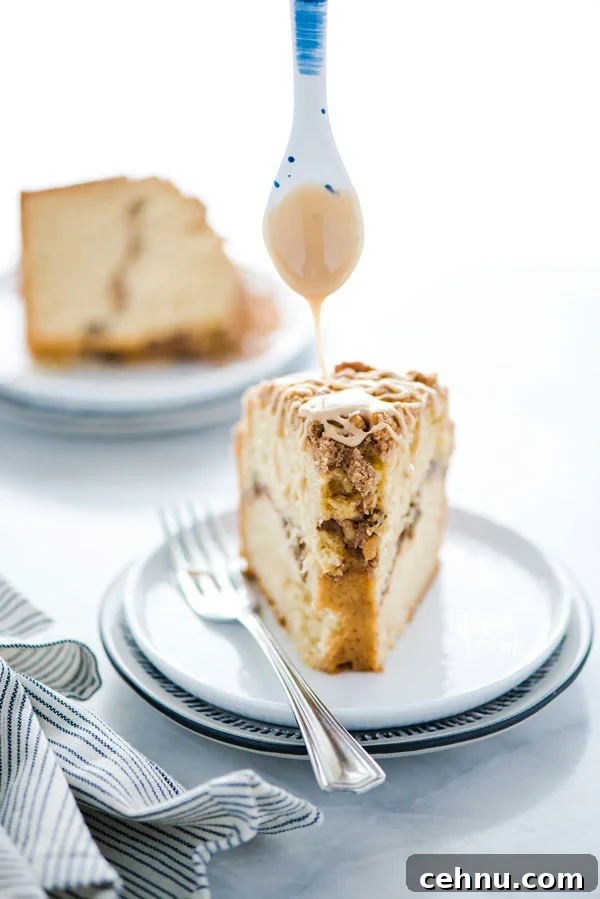 maple glaze being drizzled on a slice of gluten free sour cream coffee cake