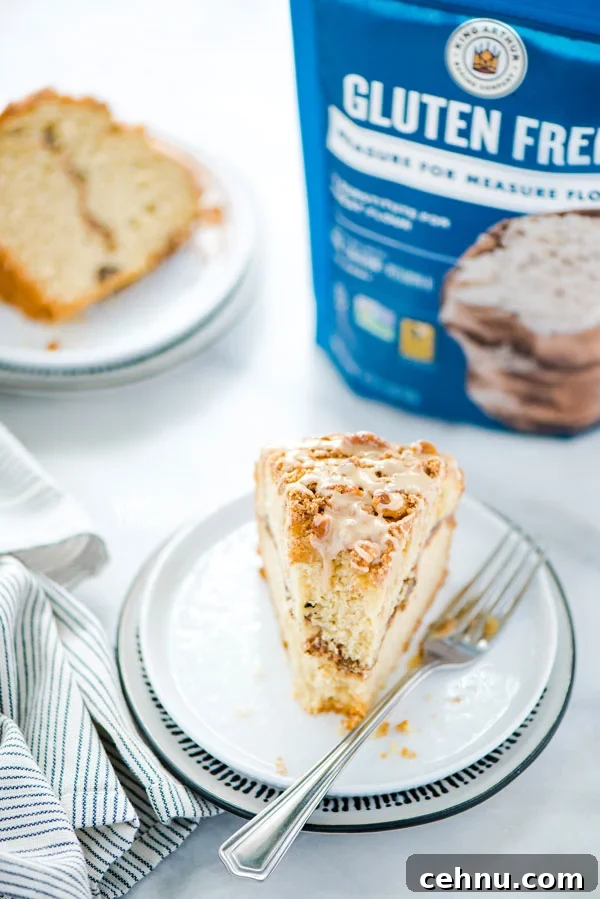 a slice of gluten free sour cream coffee cake on a white plate with a bag of King Arthur Gluten Free Measure for Measure Flour in the background