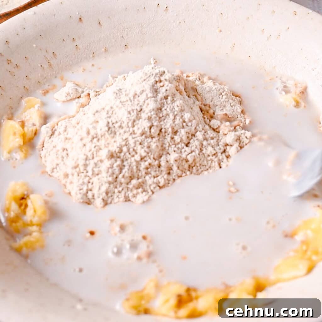 3-Ingredient Banana Bread Recipe: Moist and Quick 7 Adding milk to mashed bananas and flour to make easy banana bread moist