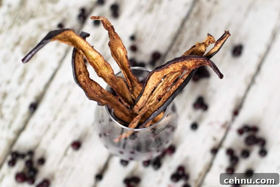 Eggplant jerky in glass with blueberries on white table