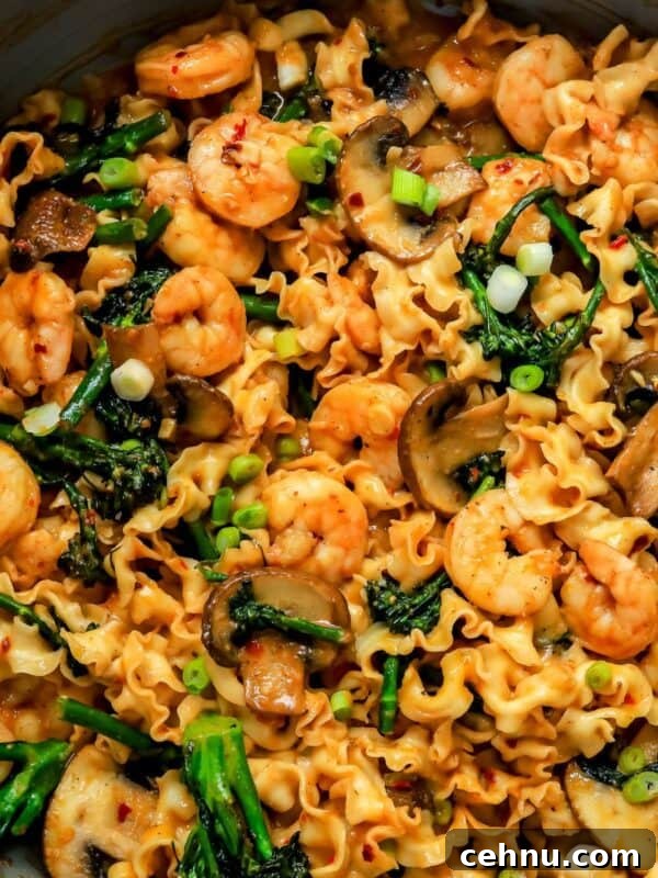 miso noodles in a skillet with broccolini and shrimp.
