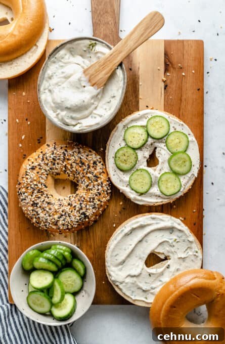 Cream cheese on bagels with cucumber slices.