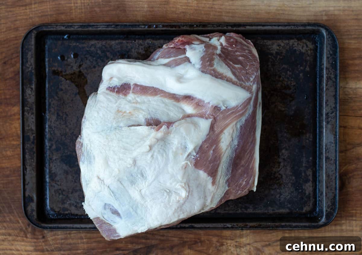 Smoked Pork Butt Recipe for Tender, Juicy Pulled Pork 4 A raw boneless Boston butt on a sheet
