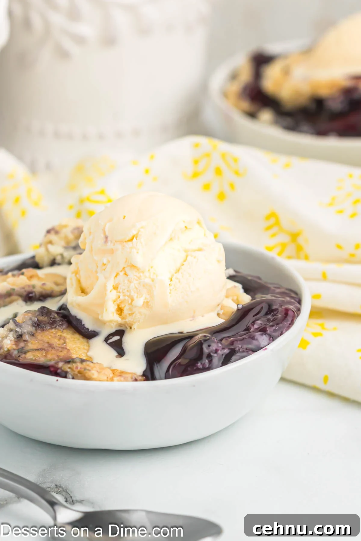 Blueberry dump cake topped with vanilla ice cream in a bowl